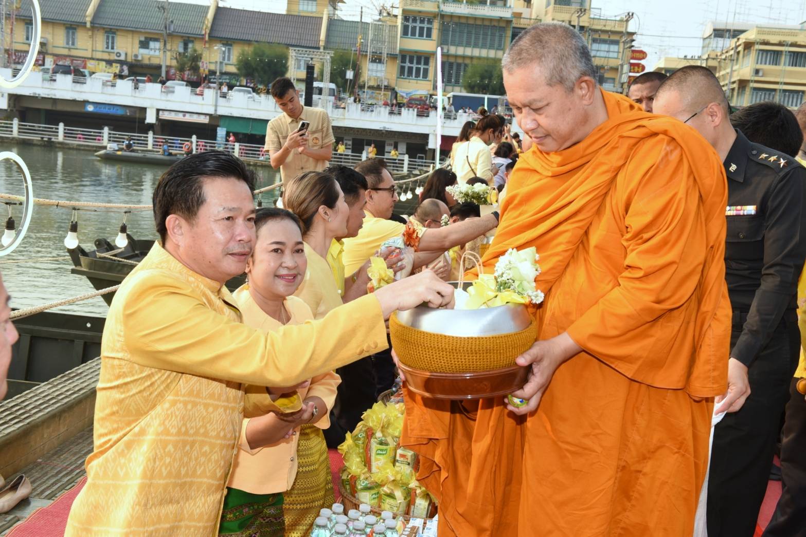📣 พช.ราชบุรีสวมใส่ผ้าไทย ร่วมทำบุญตักบาตรบนสะพานM4 กลางแม่น้ำแม่กลอง เสริมสิริมงคลเมืองราชบุรี